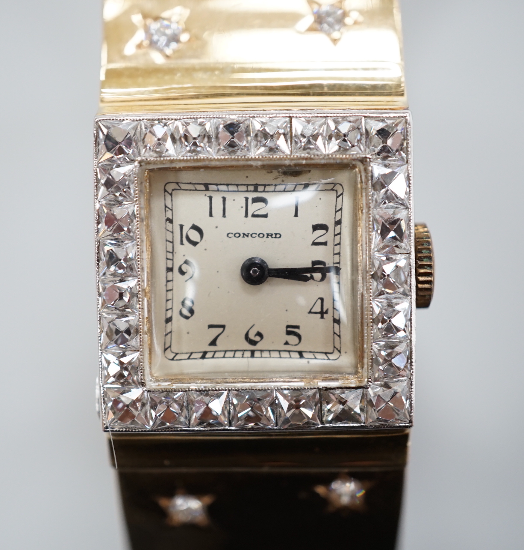 A yellow metal and diamond set Concorde manual wind open bracelet watch, with diamond set bezel and bracelet, gross weight 47.8 grams.